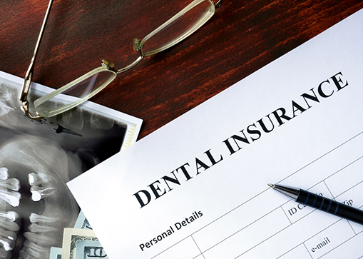 a dental insurance form with an X ray and money underneath it