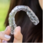 Hand holding a clear aligner tray