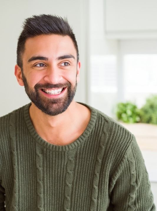 Man in green sweater smiling