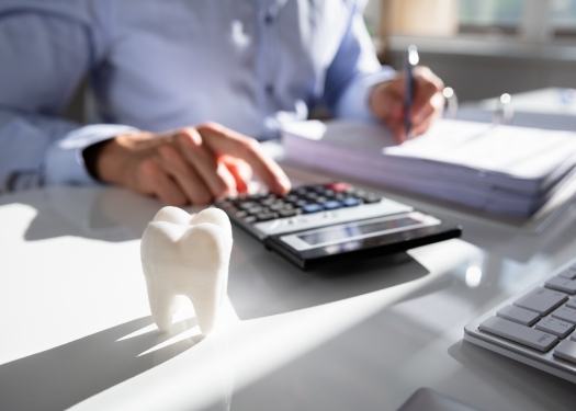 Person at desk typing on calculator