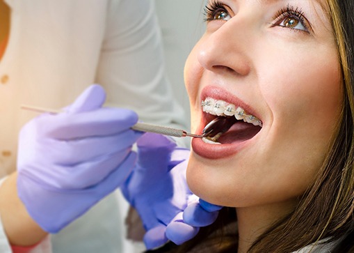 Young woman with braces receiving a dental exam