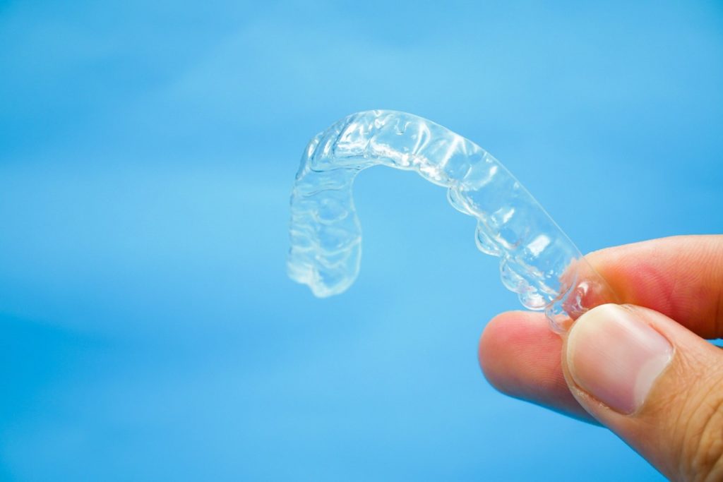Patient holding up ClearCorrect® retainer