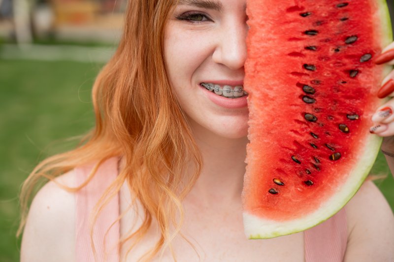 a woman with braces eating watermelon during summer
