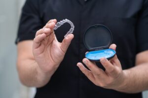 Dentist holding clear aligner tray